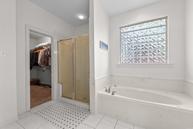 109 Sandstone Cv, Sherwood, AR 72120 - bathroom with a walk in closet, a shower stall, a garden tub, and tile patterned floors