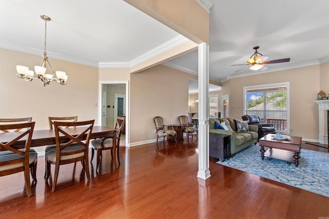 109 Sandstone Cv, Sherwood, AR 72120 - dining area featuring baseboards, ceiling fan with notable chandelier, wood finished floors, crown molding, and a fireplace