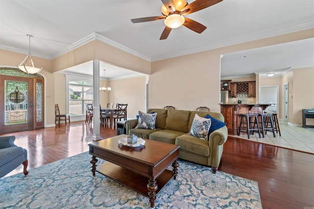109 Sandstone Cv, Sherwood, AR 72120 - living room with baseboards, crown molding, light wood finished floors, and ceiling fan with notable chandelier