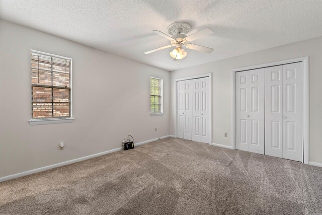 8302 Merriwood Ct, Sherwood, AR 72120 - unfurnished bedroom with two closets, baseboards, a textured ceiling, and carpet