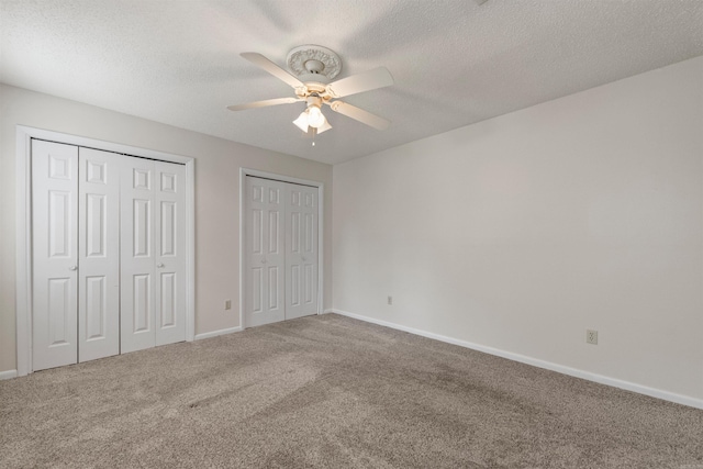 8302 Merriwood Ct, Sherwood, AR 72120 - unfurnished bedroom with baseboards, carpet, a textured ceiling, and two closets
