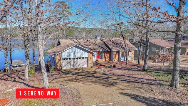 view of front of property with concrete driveway and a water view
