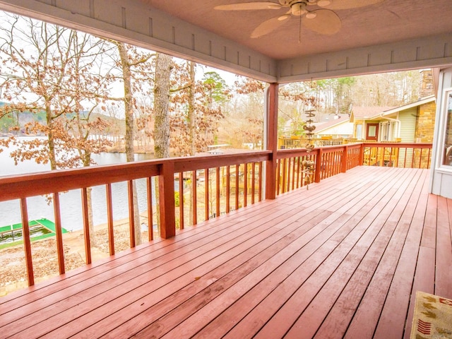 wooden deck with a ceiling fan and a water view