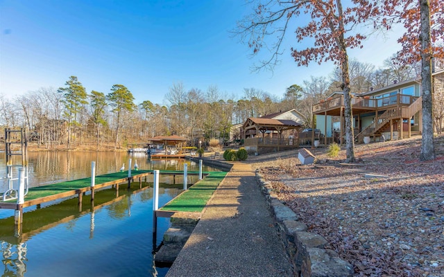 dock area with stairs, a gazebo, and a deck with water view