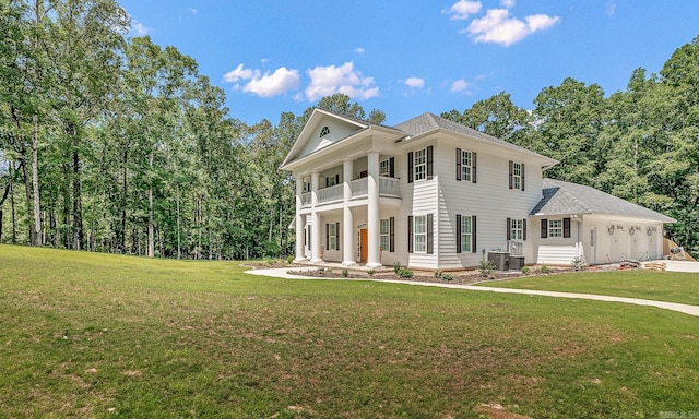 greek revival inspired property with a front lawn and a balcony