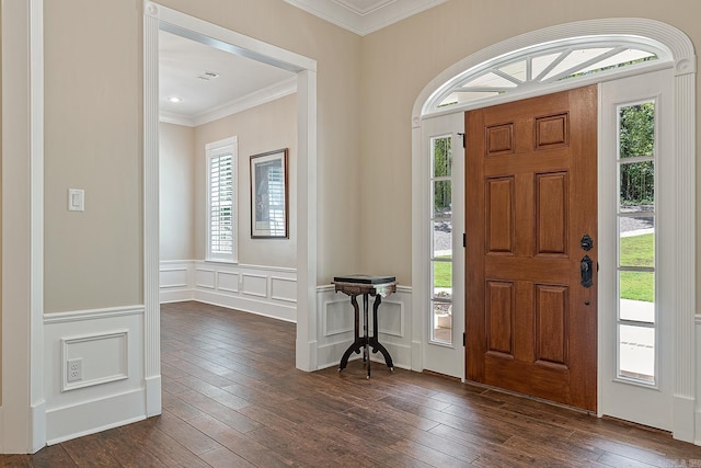 foyer with a decorative wall, a healthy amount of sunlight, dark wood-type flooring, and crown molding