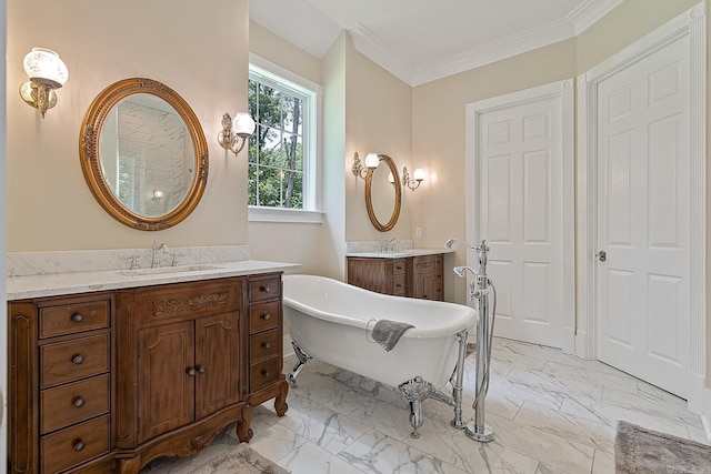 full bath featuring marble finish floor, two vanities, a freestanding tub, and a sink