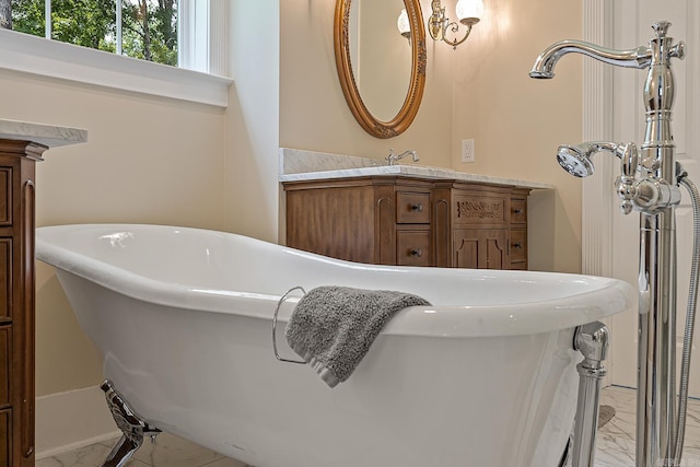 bathroom with vanity, marble finish floor, and a freestanding tub