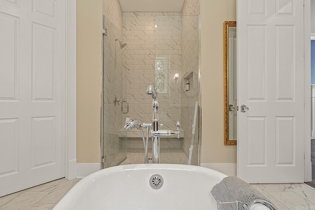 full bathroom featuring a freestanding tub, marble finish floor, and a stall shower