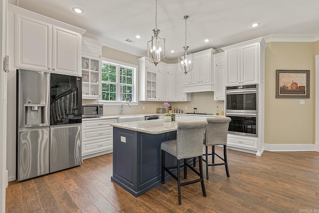 kitchen featuring ornamental molding, appliances with stainless steel finishes, a chandelier, and white cabinetry