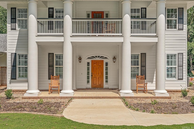 doorway to property featuring a porch and a balcony