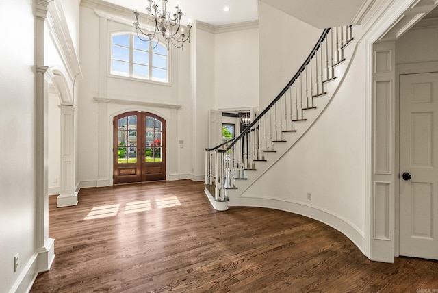 entryway with stairway, french doors, dark wood finished floors, a high ceiling, and a notable chandelier