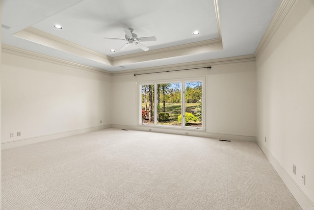 unfurnished room with a ceiling fan, carpet floors, crown molding, and a tray ceiling