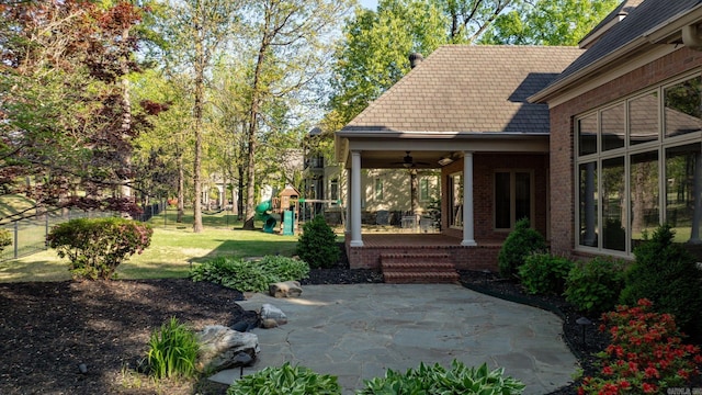 view of yard with a ceiling fan, a patio, and a playground