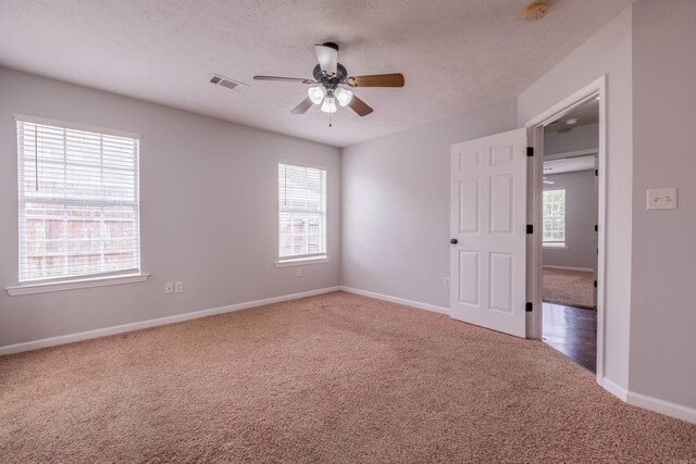 unfurnished bedroom featuring baseboards, carpet flooring, and visible vents