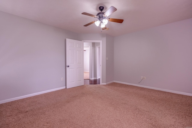 empty room with ceiling fan, carpet floors, and baseboards