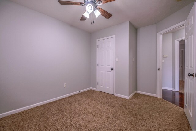 unfurnished bedroom featuring carpet floors, a ceiling fan, and baseboards