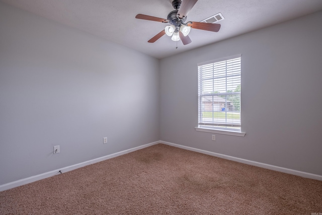 carpeted empty room featuring baseboards, a ceiling fan, and visible vents