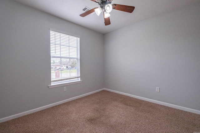 empty room featuring baseboards, visible vents, carpet floors, and ceiling fan