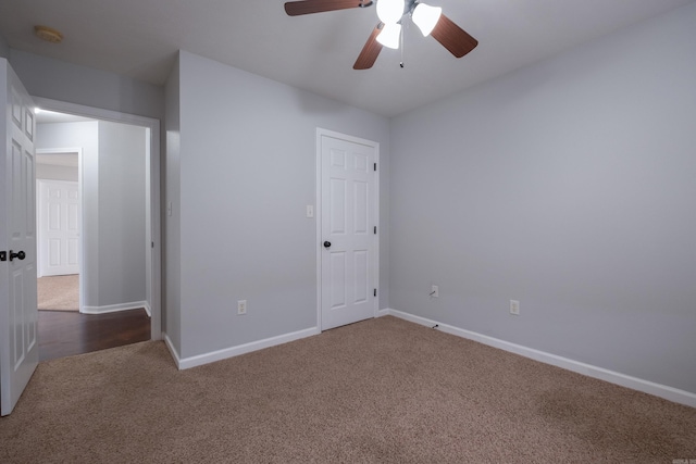 unfurnished bedroom with carpet floors, a ceiling fan, and baseboards