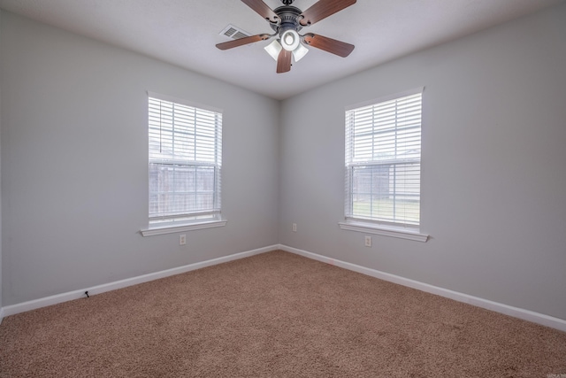 spare room with visible vents, carpet flooring, baseboards, and ceiling fan