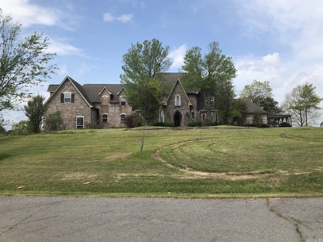 view of front of property with stone siding and a front yard