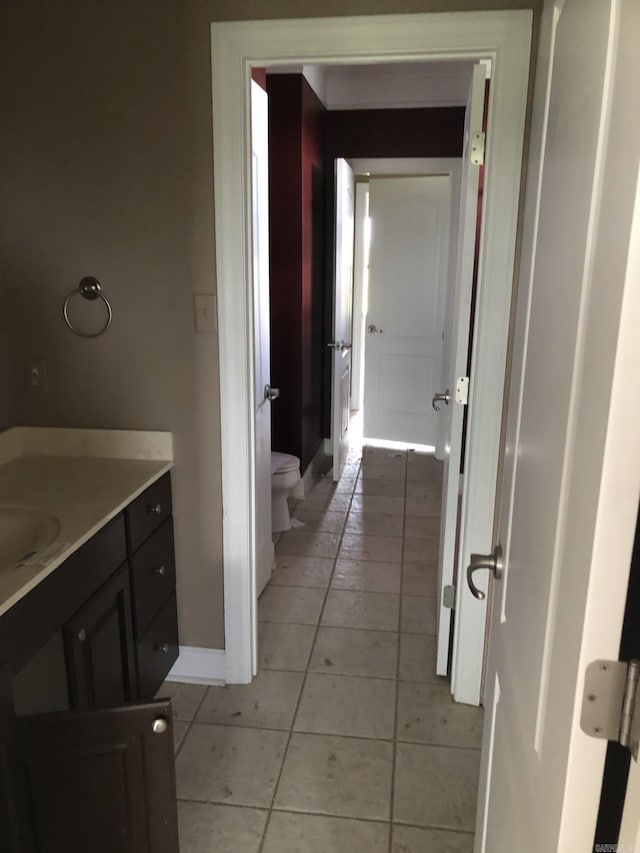 bathroom with vanity, toilet, tile patterned flooring, and baseboards