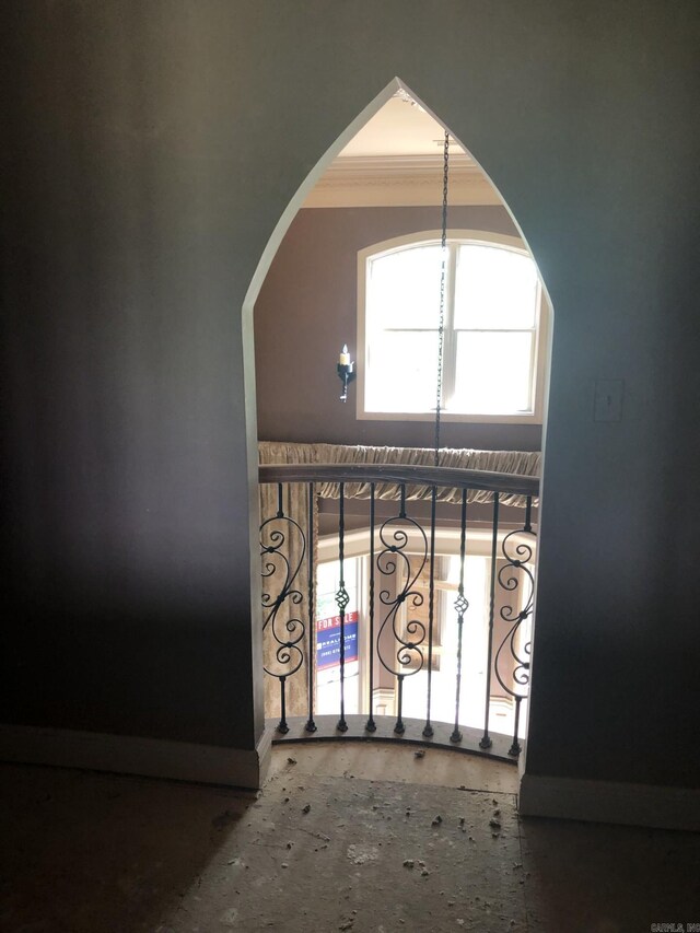 details with baseboards, arched walkways, and ornamental molding