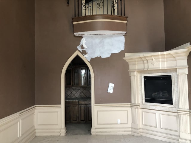 unfurnished living room with a decorative wall and a wainscoted wall