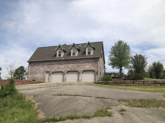 view of side of home featuring driveway and brick siding