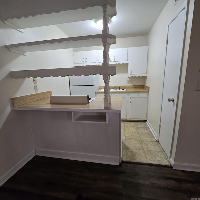 200 N Fillmore St, Little Rock, AR 72205 - kitchen featuring a kitchen breakfast bar, light countertops, freestanding refrigerator, baseboards, and white cabinetry