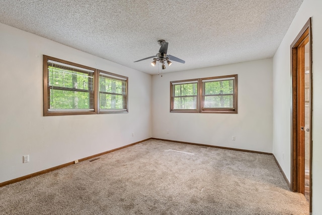 empty room featuring baseboards, carpet floors, a textured ceiling, and ceiling fan