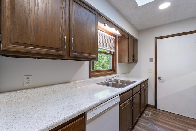 kitchen with dark brown cabinets, white dishwasher, a sink, light countertops, and dark wood finished floors