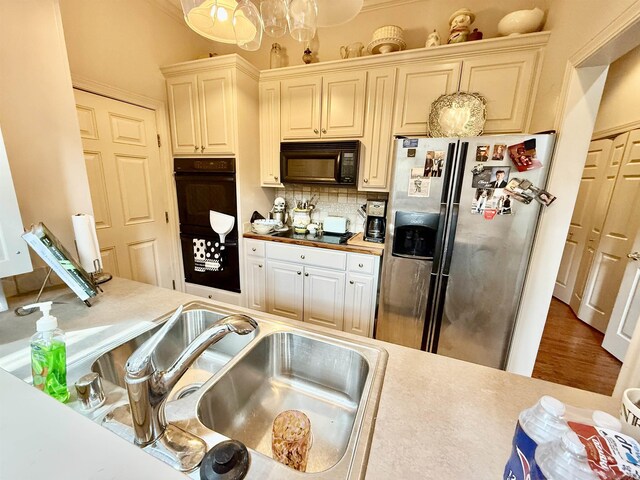 2308 Saxony Blvd, Searcy, AR 72143 - kitchen featuring light countertops, a sink, decorative backsplash, black appliances, and cream cabinets