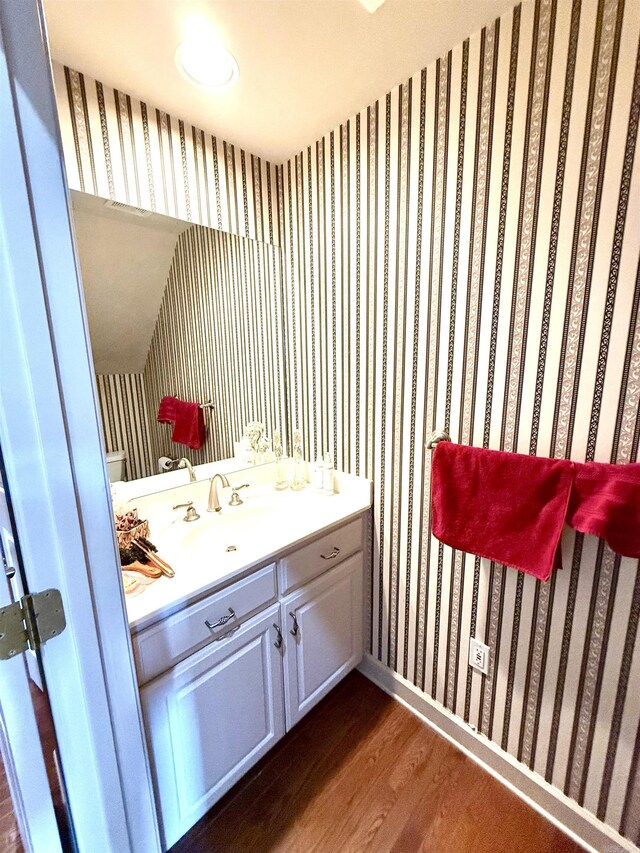 2308 Saxony Blvd, Searcy, AR 72143 - bathroom featuring baseboards, wallpapered walls, wood finished floors, and vanity