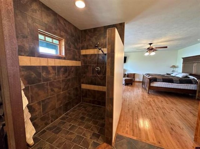 ensuite bathroom with ceiling fan, tiled shower, and connected bathroom