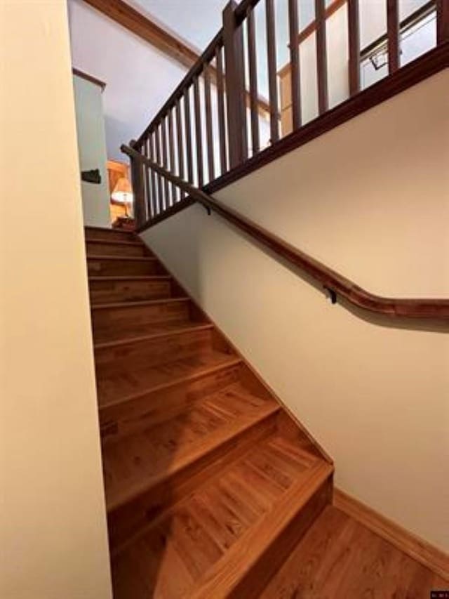 stairway featuring wood finished floors and baseboards