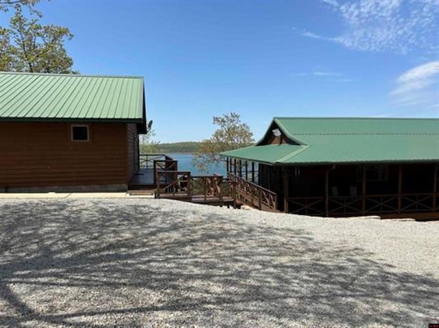 view of property exterior with metal roof and a water view