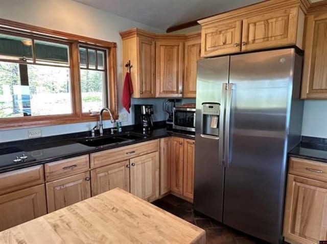 kitchen featuring dark countertops, appliances with stainless steel finishes, and a sink