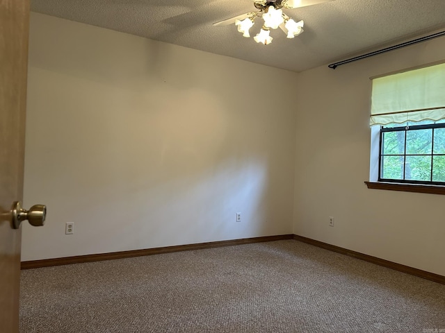 spare room featuring carpet floors, a textured ceiling, and ceiling fan