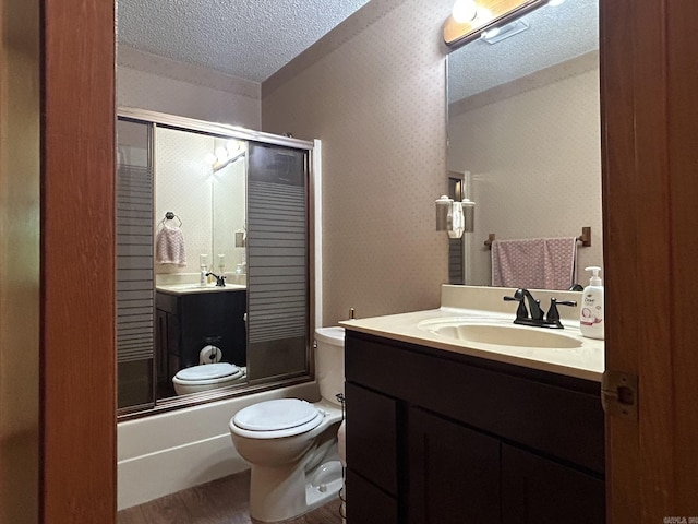 full bath with wood finished floors, a textured ceiling, toilet, and enclosed tub / shower combo