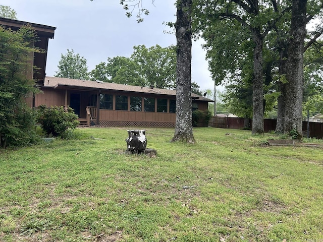view of yard featuring fence and a sunroom