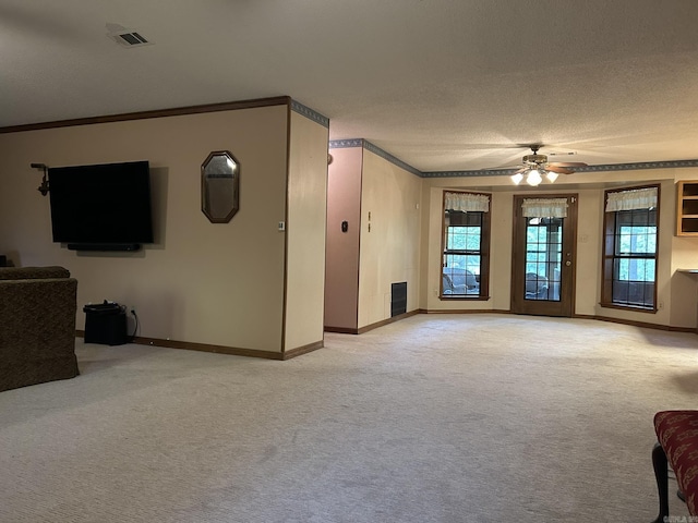unfurnished living room featuring ceiling fan, crown molding, baseboards, and light carpet