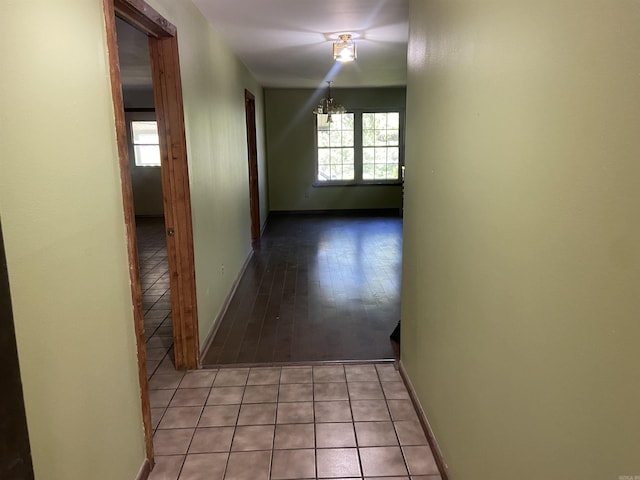 hallway with baseboards and light tile patterned flooring