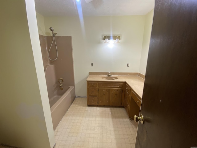 full bath featuring tile patterned floors, vanity, and washtub / shower combination