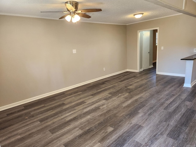 empty room featuring dark wood-style floors, ornamental molding, baseboards, a textured ceiling, and ceiling fan