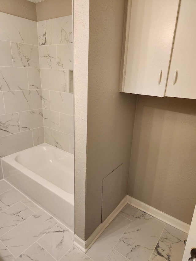 full bath featuring marble finish floor and baseboards