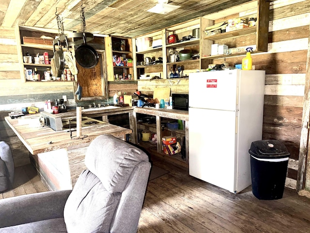kitchen with open shelves, wood-type flooring, and freestanding refrigerator