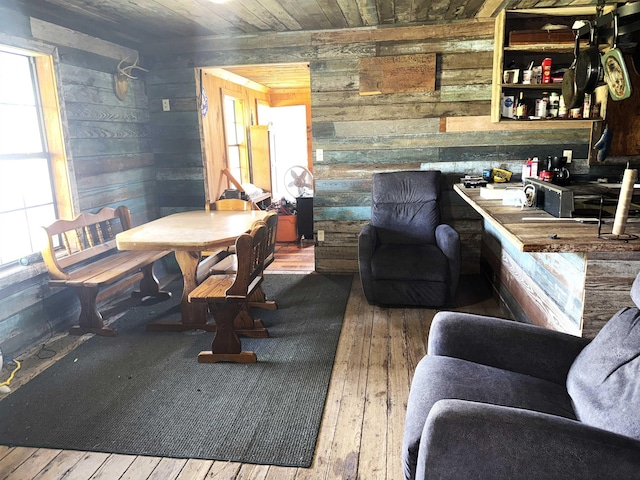 living area featuring wood ceiling, wooden walls, plenty of natural light, and hardwood / wood-style flooring