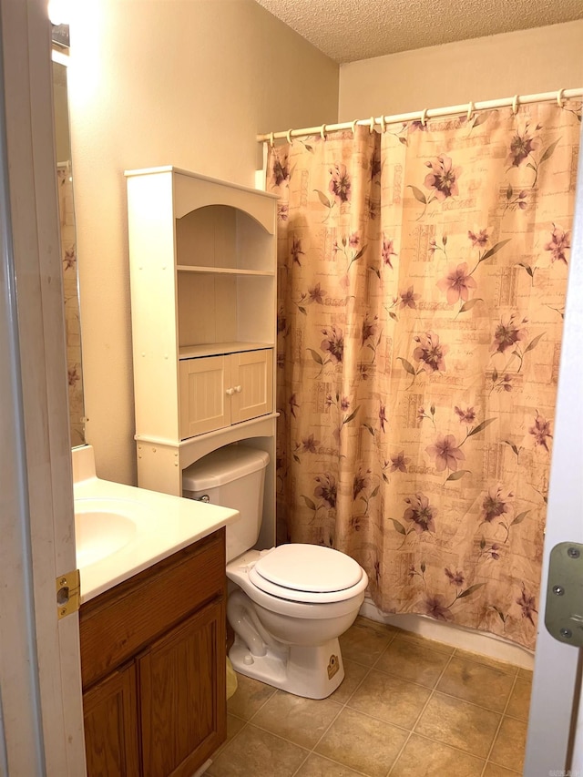 bathroom with toilet, tile patterned floors, vanity, and a textured ceiling